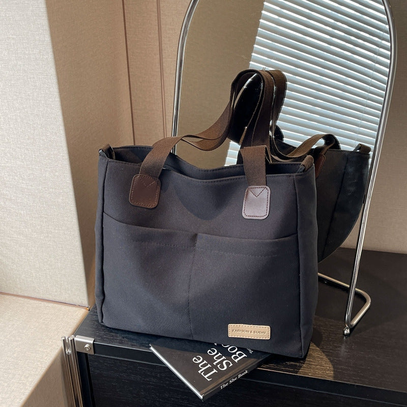 Stylish black canvas tote bag with detachable shoulder strap