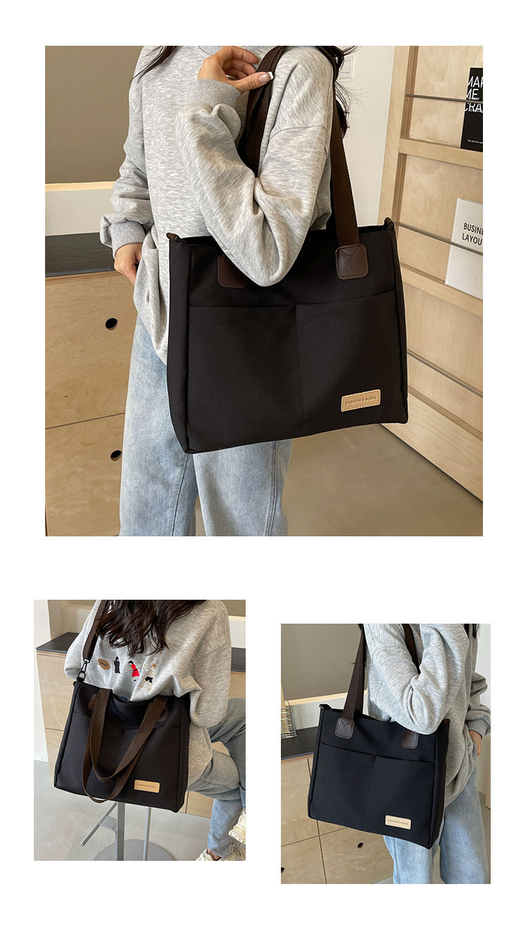 Stylish black canvas tote bag with detachable shoulder strap